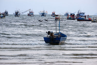 Boats sailing in sea against sky