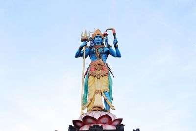 Low angle view of statue against blue sky