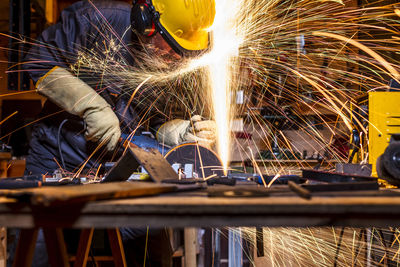 Man grinding metal in factory