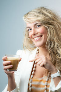 Portrait of a smiling young woman drinking glass