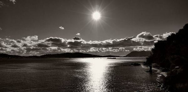 Scenic view of sea against bright sun