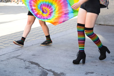 People holding rainbow flag during parade in city