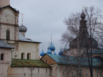 Low angle view of buildings and trees against sky