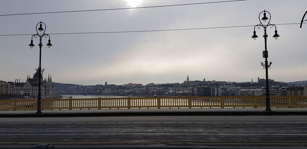 Bridge over river against sky in city