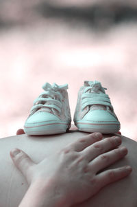 Low section of woman holding shoes