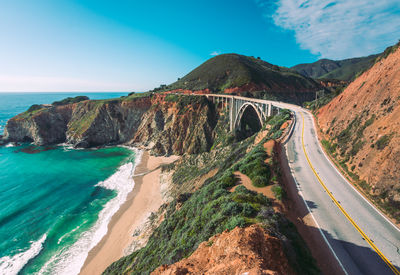 Panoramic shot of road by sea against blue sky