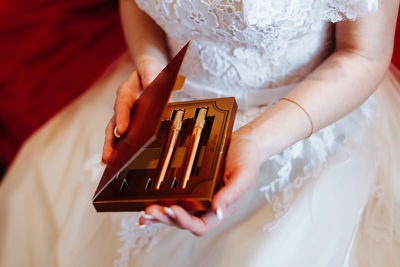 Midsection of bride holding box