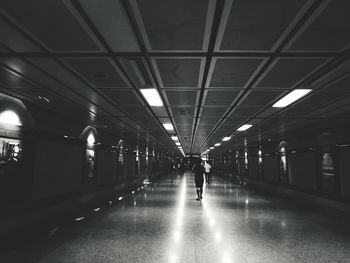 Man walking in illuminated underground walkway