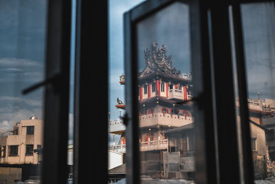 Low angle view of buildings seen through glass window