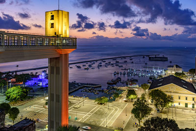 Lacerda elevator illuminated at dusk and with the sea and boats in the background in salvador, bahia