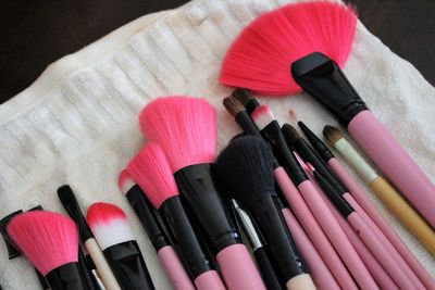 High angle view of various make-up brushes on towel