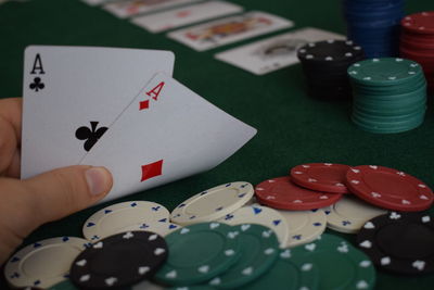 Close-up of hand holding cards with coins