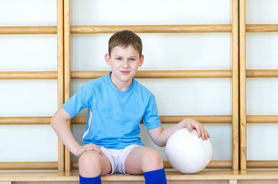 Portrait of boy sitting with ball