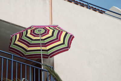 Low angle view of parasol at building balcony