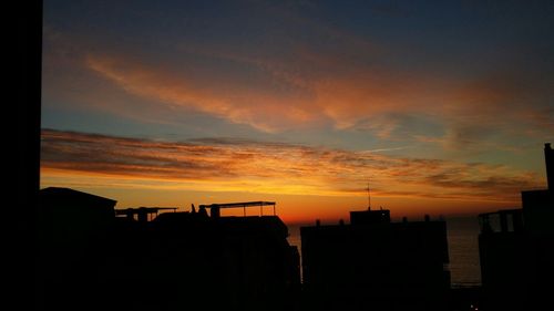 Silhouette of buildings against sky during sunset