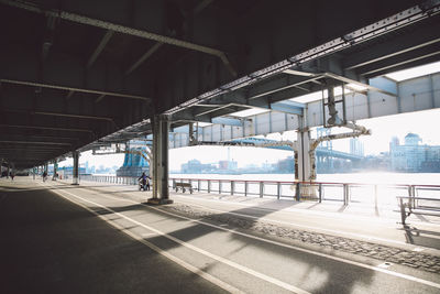 Walkway below elevated road in manhattan on sunny day