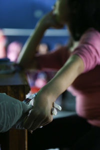 High angle view of doctor injecting syringe on woman hand