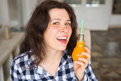 Portrait of a smiling young woman holding ice cream