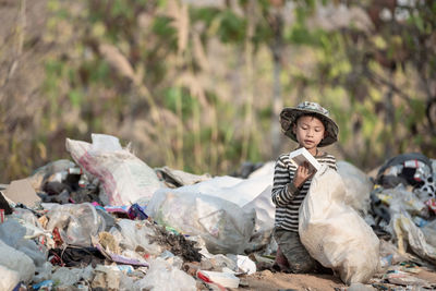 Portrait of young man sitting on garbage