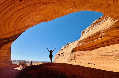 Silhouette man standing on rock formations