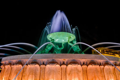 Close-up of illuminated lighting equipment against black background