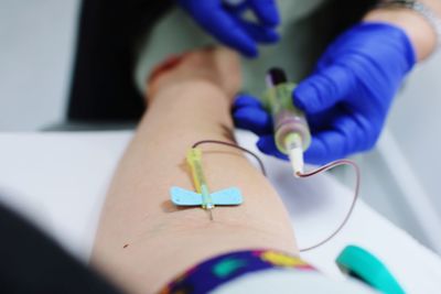 Cropped image of doctor giving iv drip to patient in hospital