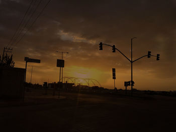 Street lights against sky during sunset