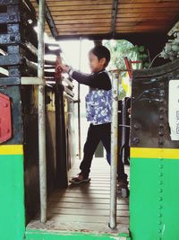 Full length of boy standing in corridor of building