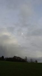 Scenic view of grassy field against cloudy sky