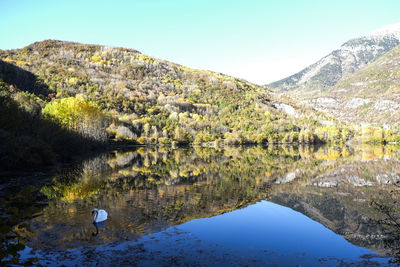 Scenic view of lake and mountains against blue sky