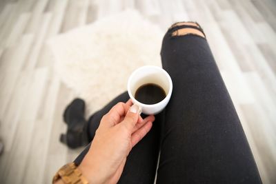 Midsection of person holding coffee cup