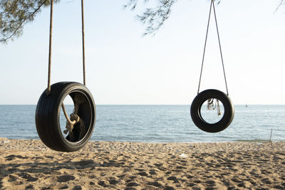 View of wheel at beach against clear sky