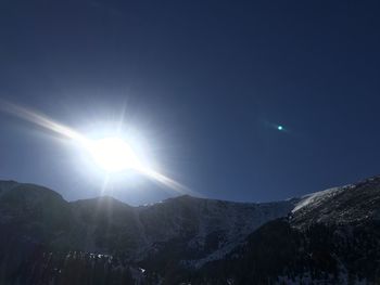 Low angle view of bright sun in sky