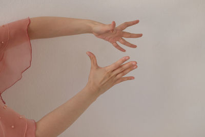 Midsection of woman with hands against white background