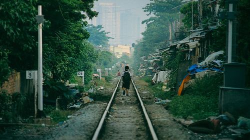 Man on railroad track against sky