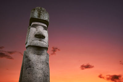 Low angle view of statue against sky at sunset