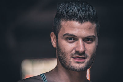 Portrait of shirtless young man smiling outdoors