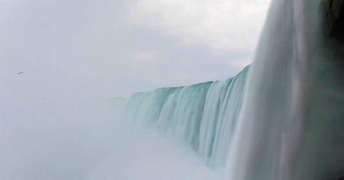 Low angle view of waterfall against sky