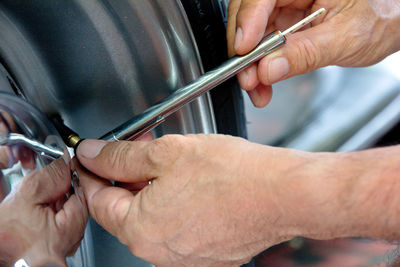 Cropped image of repairman working on car tire