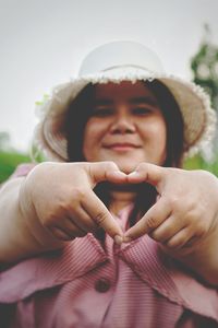 A plump woman wearing a skirt and a hat was standing with her heart in her hand.