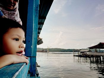 Portrait of cute girl in water against sky