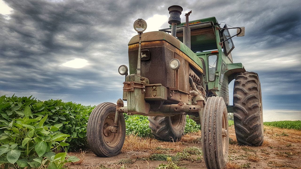 field, cloud - sky, sky, agricultural machinery, mode of transport, tractor, transportation, agriculture, land vehicle, no people, wheel, outdoors, day, tire, rural scene, low angle view, combine harvester, nature