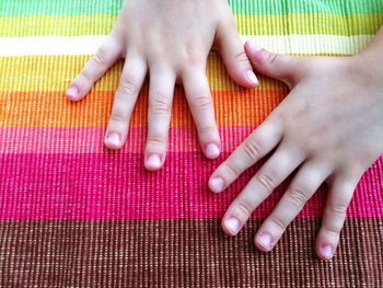 Cropped hands on multi colored tablecloth