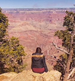 Rear view of woman standing on rock formation