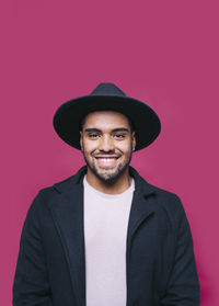 Portrait of a smiling man against red background