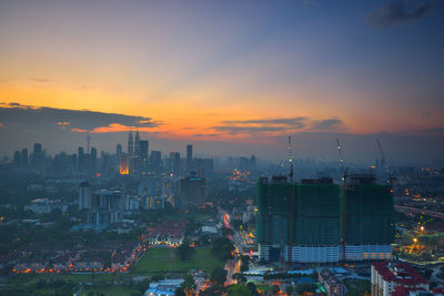 High angle view of illuminated buildings against sky during sunset