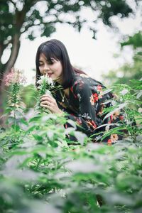 Young woman with flowers on plants