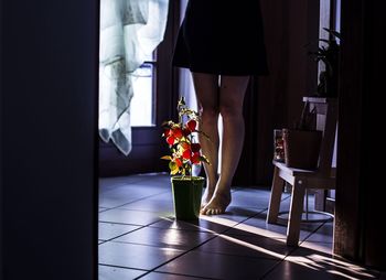 Low section of woman standing on tiled floor at home