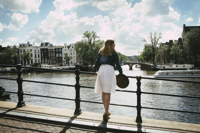 Woman in white dress overlooking city and canal