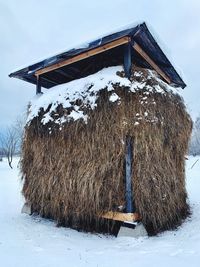 Built structure on snow covered field against sky